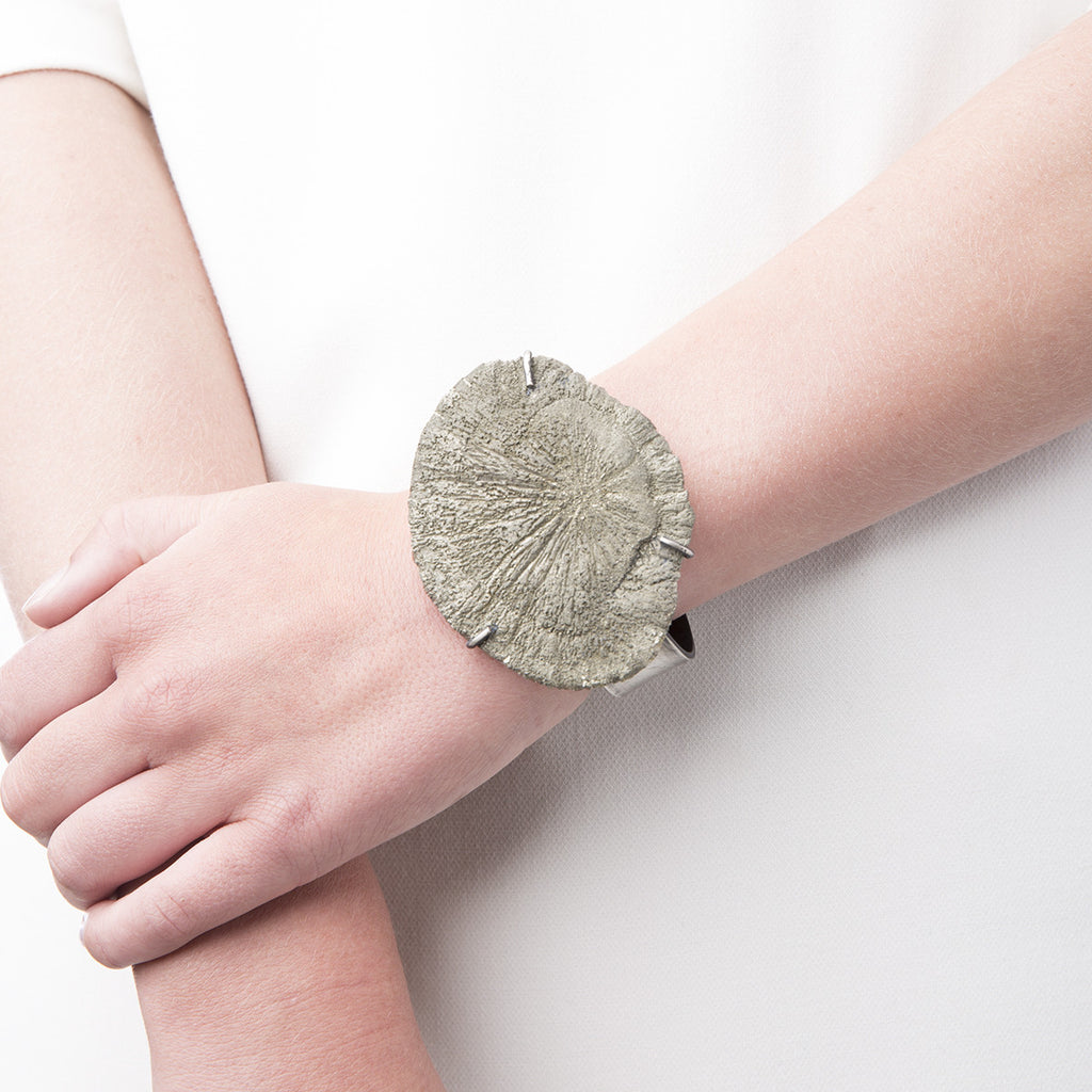 Photo of Slant Fine Jewelry's cuff bracelet of sun pyrite around a woman's wrist